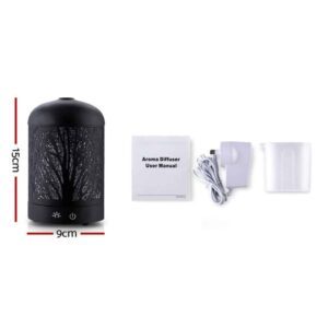 Essential oil diffuser with tree silhouette design, user manual, white power adapter, and translucent measuring cup