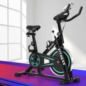 Everfit indoor cycling bike with sleek black frame and turquoise flywheel accents, adjustable seat and handlebars, digital console, positioned near sunlit window with gradient floor tones