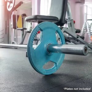 Lifestyle promotional image of CORTEX SPARTAN205 7ft 20kg Olympic barbell loaded with blue tri-grip weight plate in a gym setting, text overlay notes plates not included