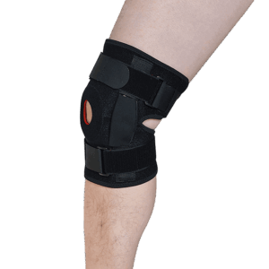 Leg wearing black knee brace with red patella ring and side reinforcements; designed for joint stability and recovery