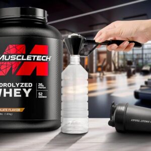 hand holding scoop of protein powder over white shaker bottle next to muscletech nitro-tech container and dumbbells in modern gym environment