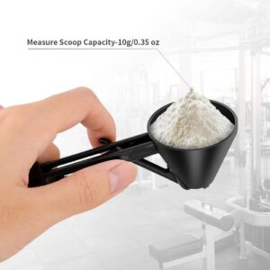 hand holding black 10g measuring scoop filled with powder, featuring funnel spout for easy pouring, with blurred gym background