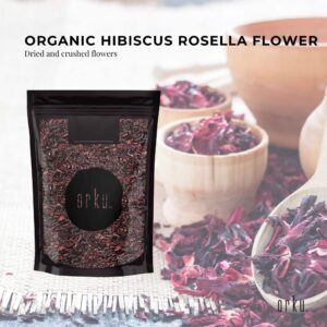 orku™ Organic Hibiscus Rosella Flower pouch with visible crushed petals, wooden bowls, spoon, and woven mat background