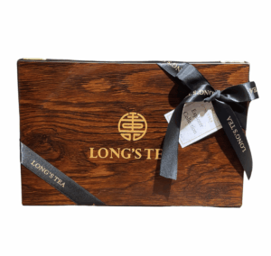 LONG'S TEA Explorer Collection gift box with dark wood grain, gold emblem, and black ribbon bow