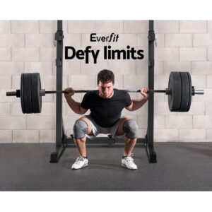 Athlete performing a heavy barbell squat using an Everfit squat rack with weight plates in a home gym strength training environment