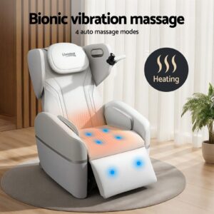 White Livemor massage chair displayed in a modern living space with wooden wall panels, curtains, and a potted plant. The chair is slightly reclined with an extended footrest, showcasing bionic vibration massage points highlighted in blue and a heated seat area indicated by a warm orange glow. On-screen text reads “Bionic vibration massage – 4 auto massage modes” and “Heating,” emphasizing built-in heat therapy and multiple massage settings for relaxation.