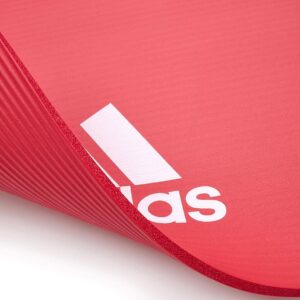 Close up of Adidas 7mm fitness mat showing textured non-slip surface and cushioned design for yoga, stretching and floor workouts