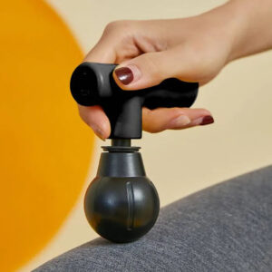 Remology mini massage gun with ball head held in hand