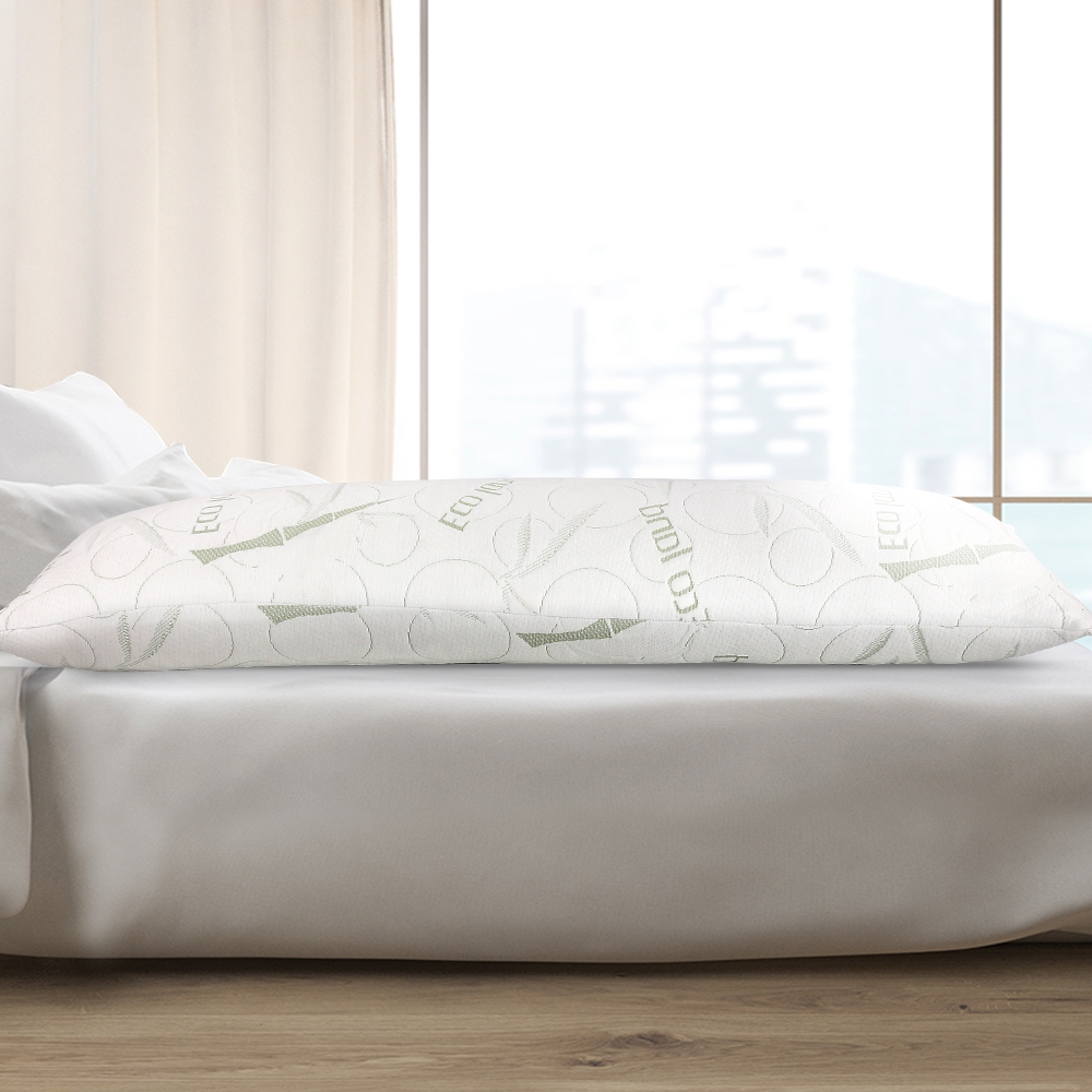 Giselle Bedding white memory-foam body pillow on a bed in a bright bedroom.